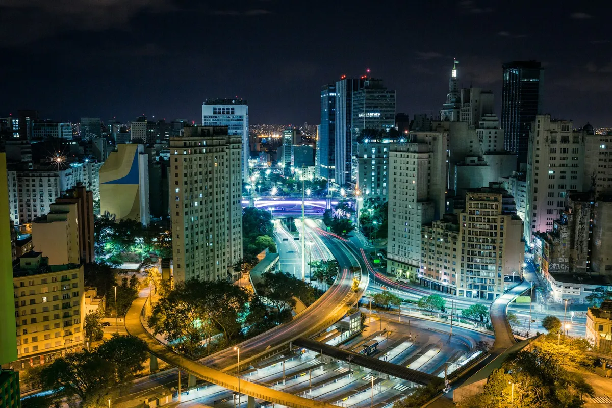 Vista noturna de São Paulo, com o trânsito iluminado nas avenidas entre os prédios