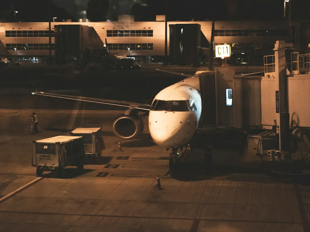 Avião acoplado à ponte de embarque no Aeroporto de Viracopos, em Campinas, à noite