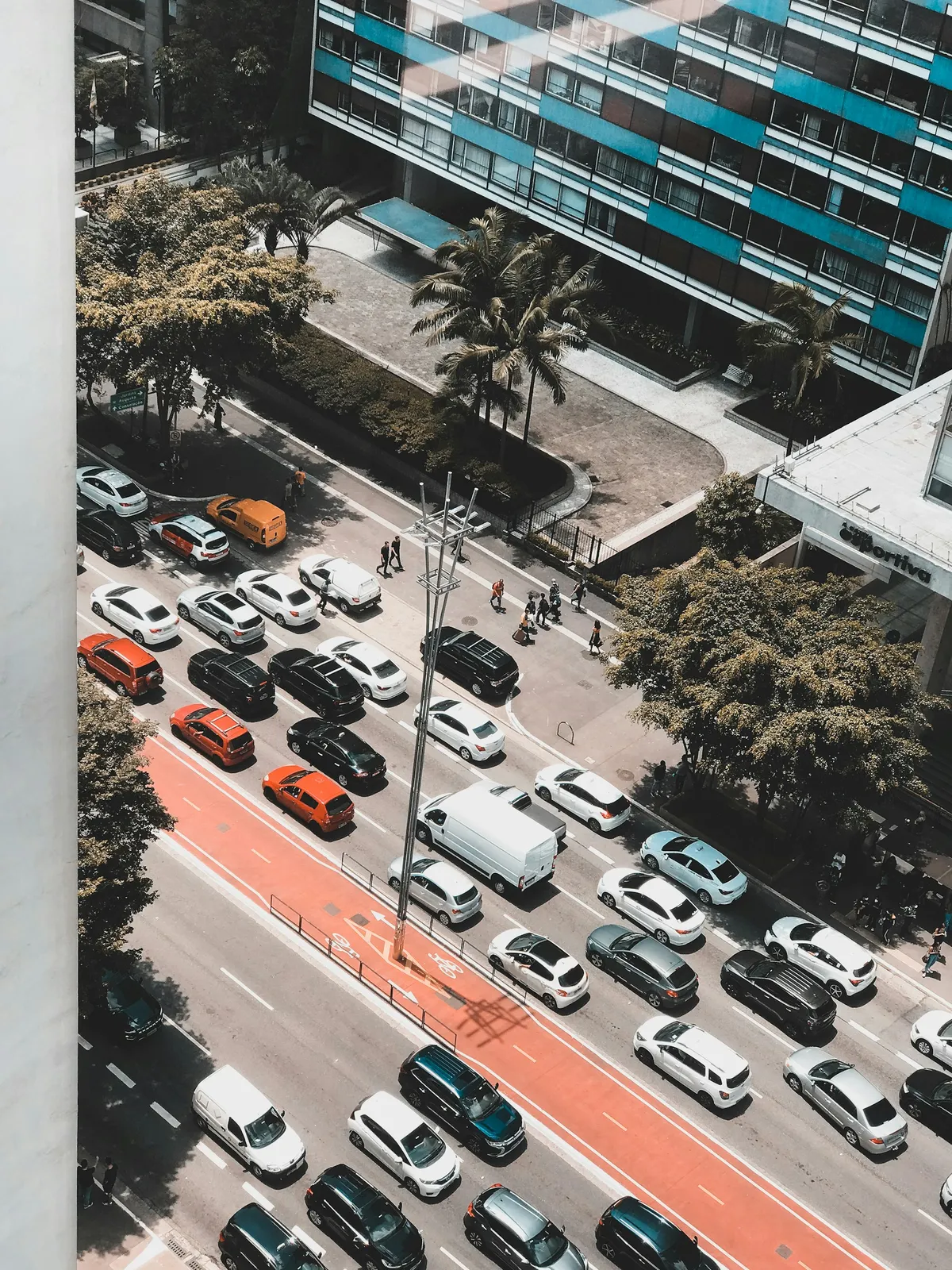 Avenida Paulista vista do alto, com trânsito de carros e ônibus entre os prédios