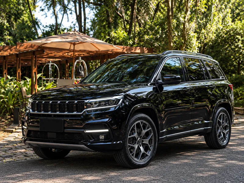 Black armored SUV parked in front of a wooded garden